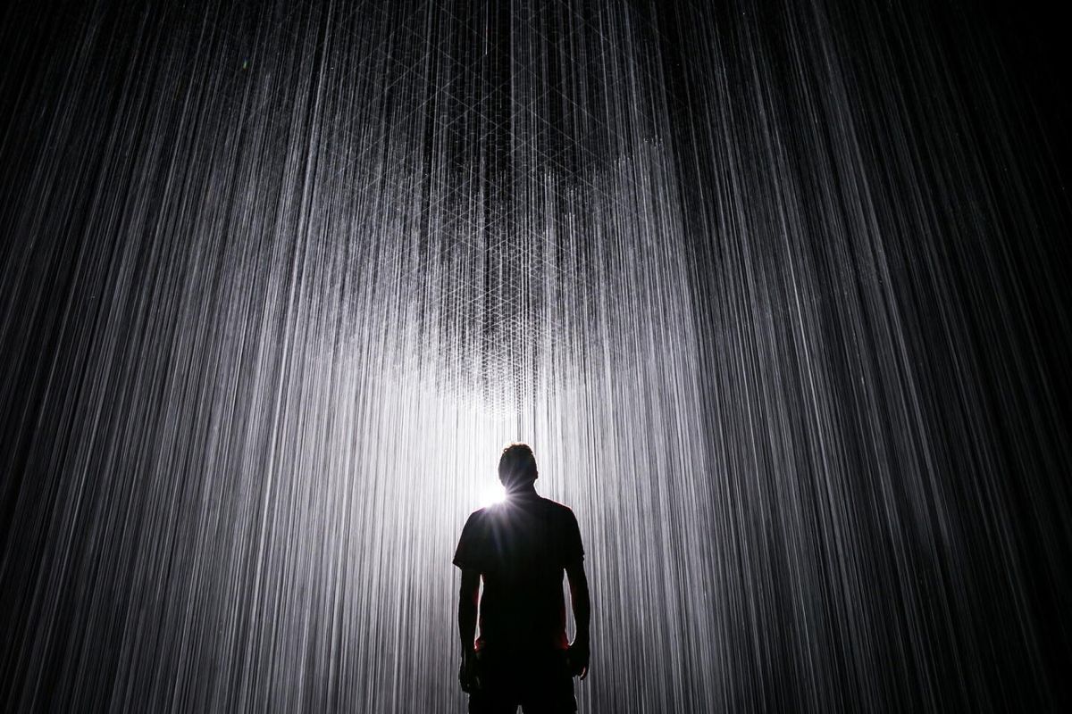 A silhouette standing in a curtain of falling light